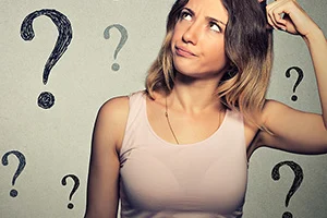 Frau hält Hand an den Kopf und schaut fragend nach oben