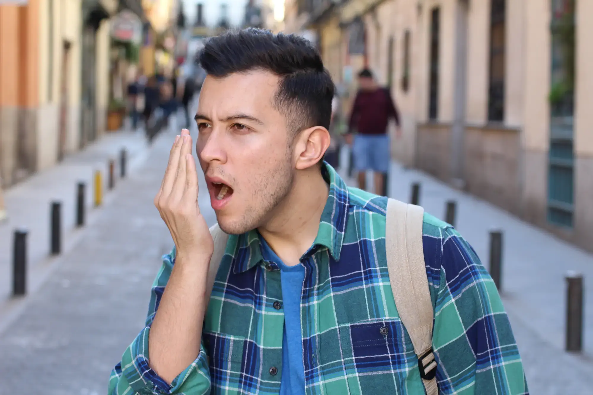 Ein Mann, der seine Hand vor seinen Mund hält und reinpustet