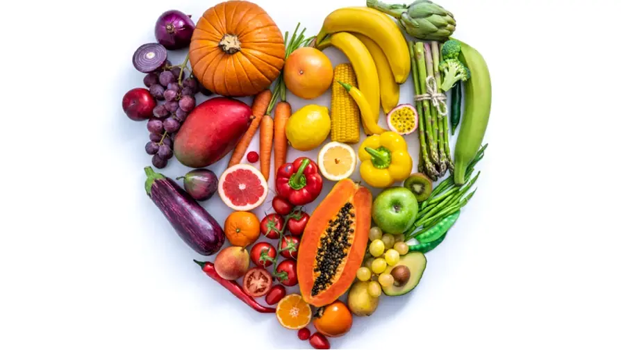 Blick von oben auf ein Herz aus verschiedenen Obst und Gemüse