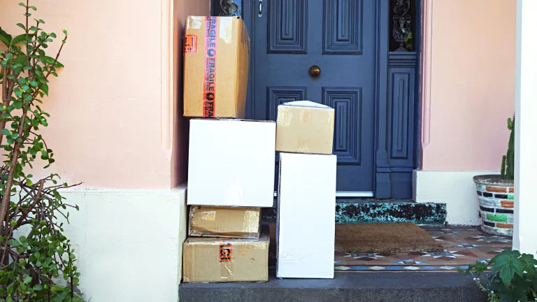 Seis caixas empilhadas na frente da porta de uma casa.