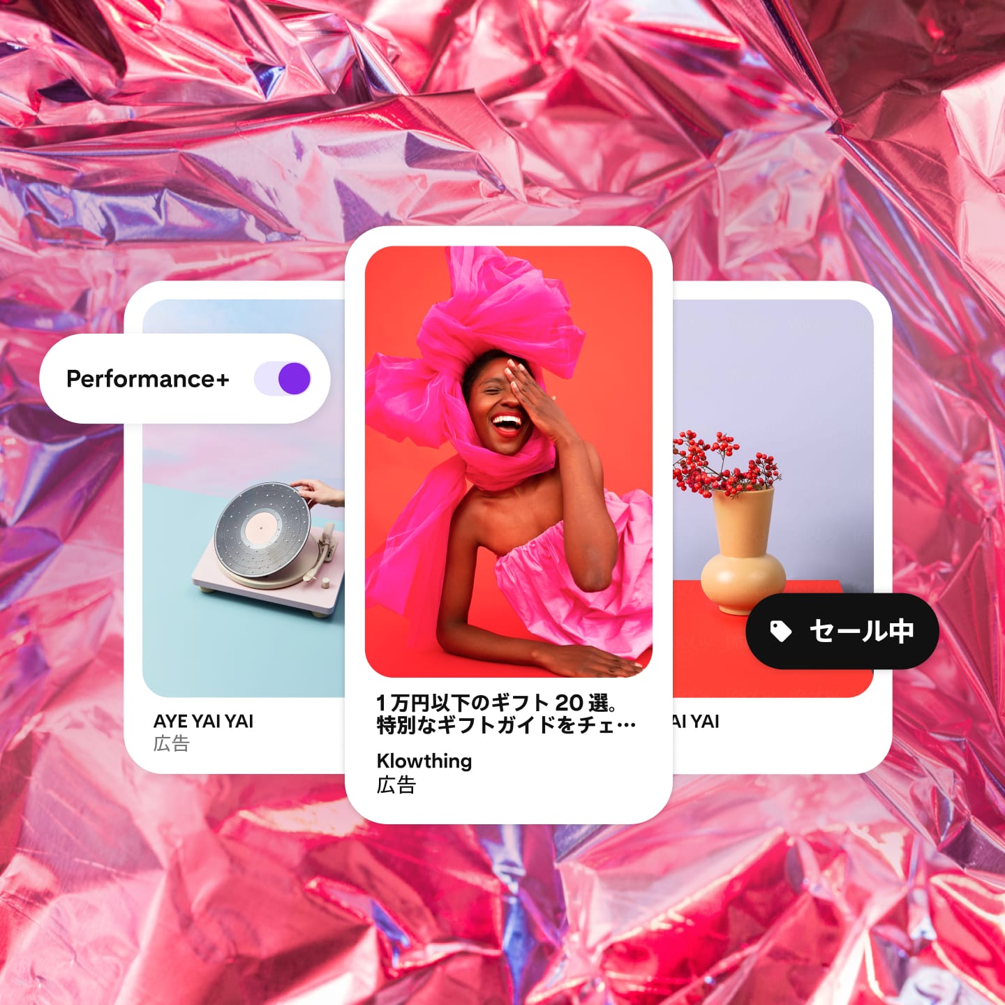ピンクのセロファンラッパーの背景の上に表示されている 3 つのピン、セールボタン、Performance+ ボタン。中央の画像はホットピンクのドレスを着た女性。左の画像はレコードプレーヤーで、右の画像は果実が飾られた花瓶。