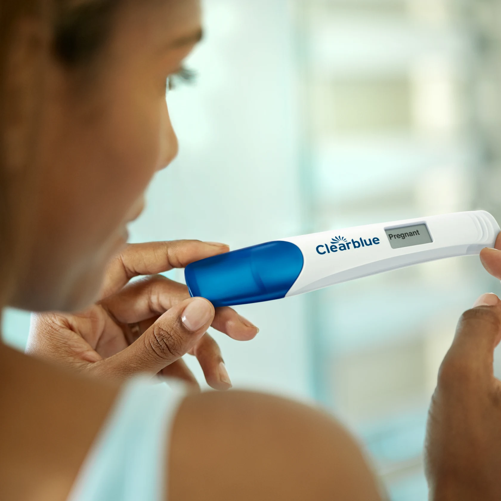 Women holds pregnancy test that reads "Pregnant" 