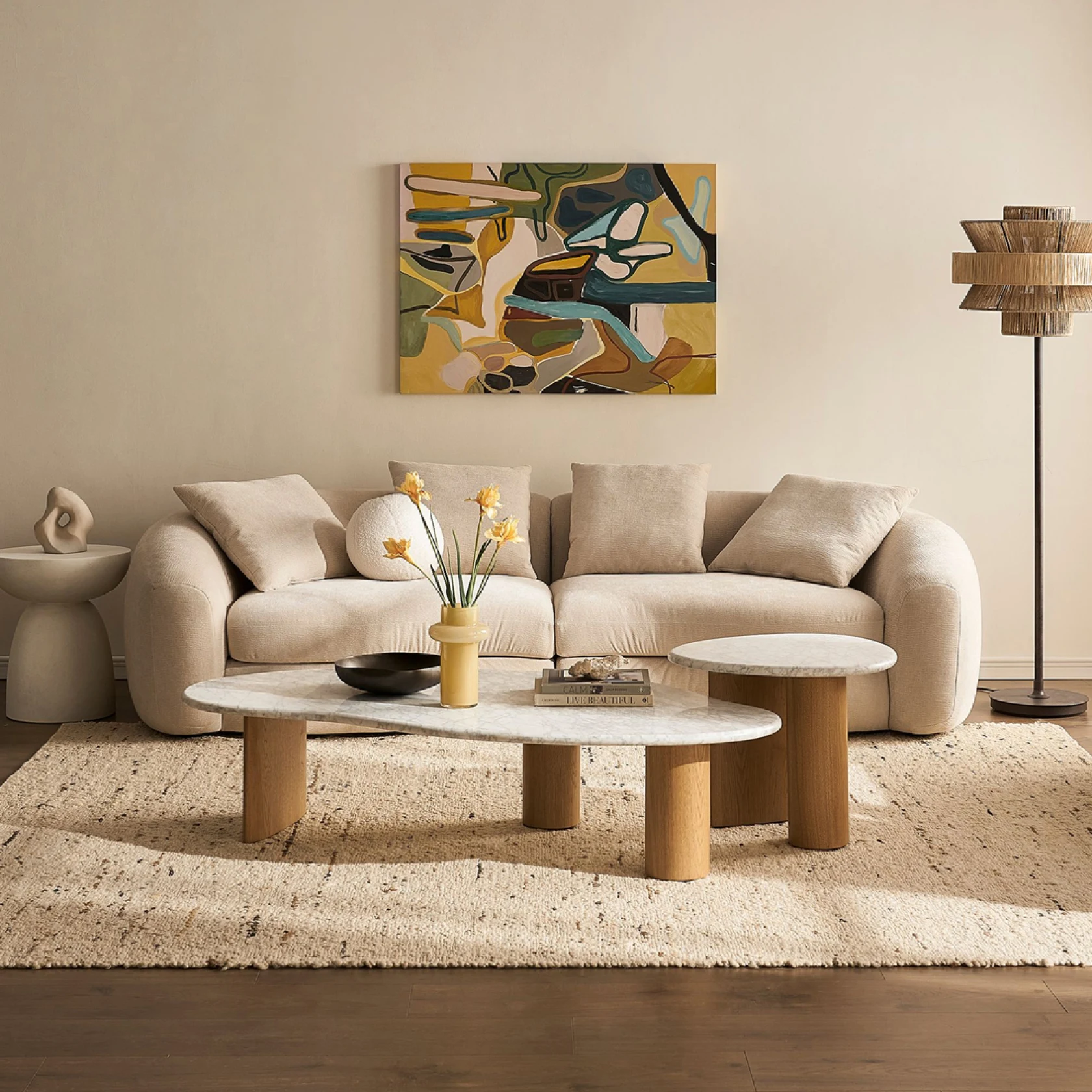 Beautiful cream couch with stylish coffee table, art, and standing lamp