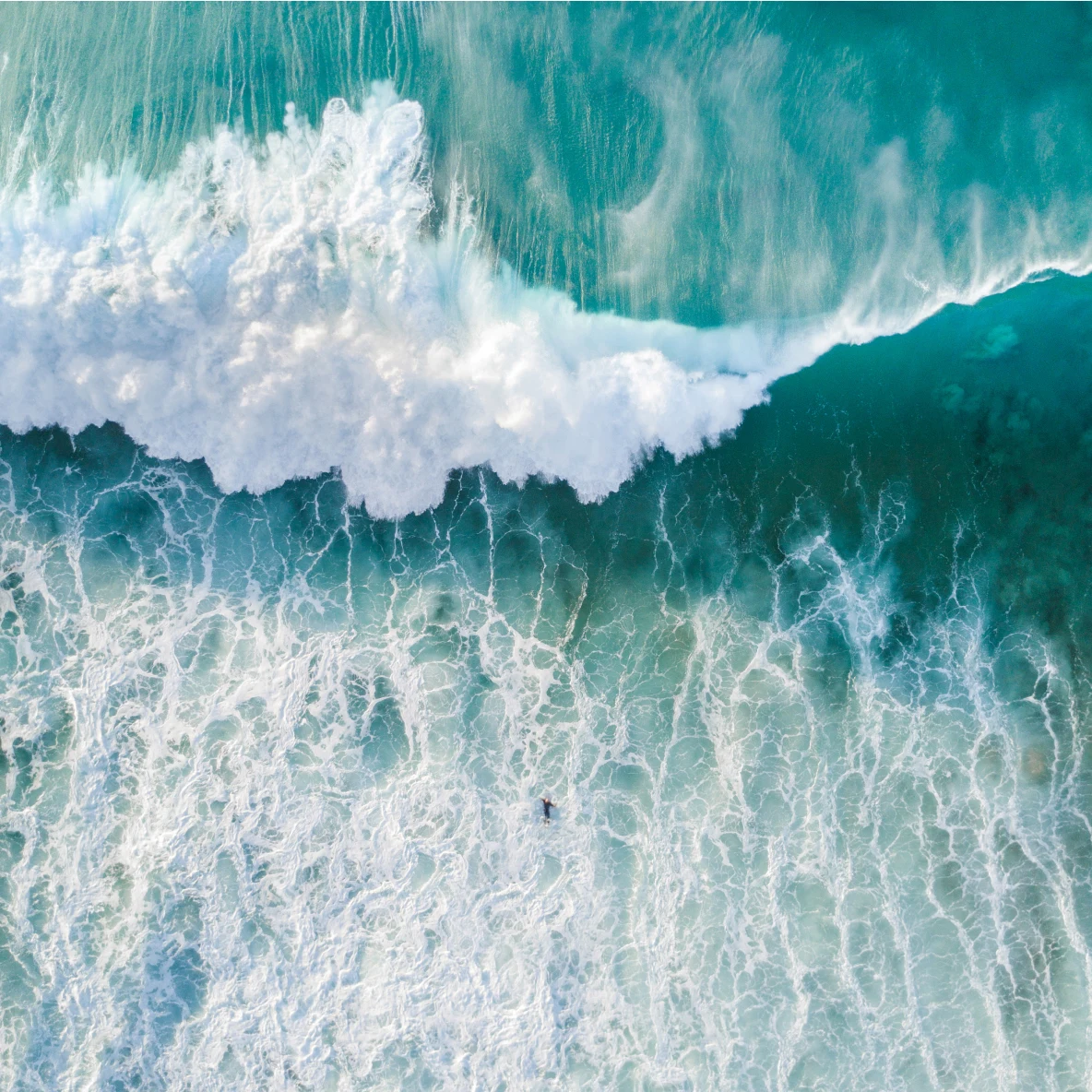 Aerial view of a blue-green crashing wave