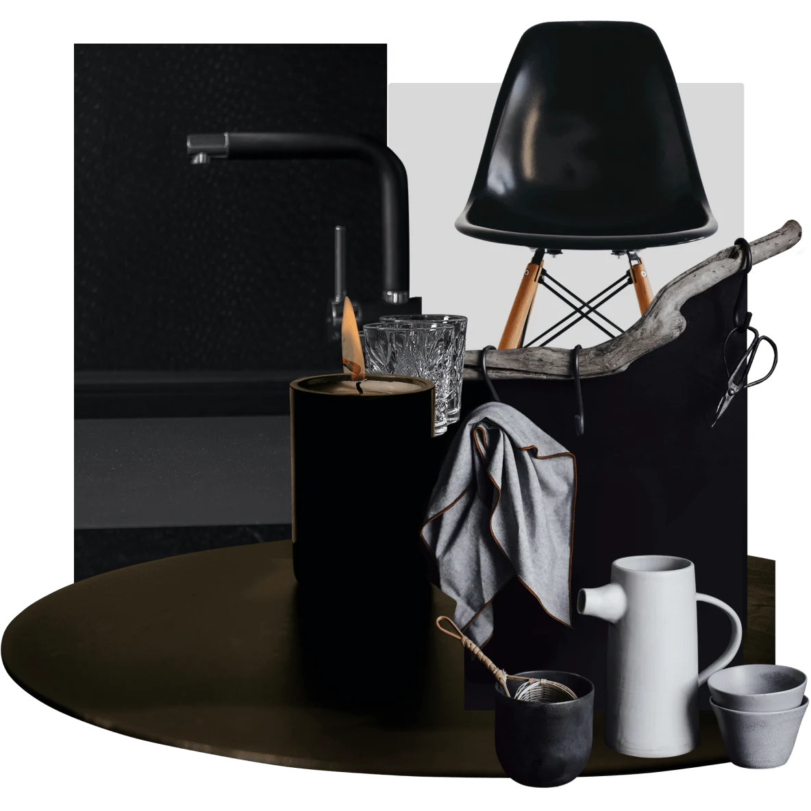 Vela preta, xícaras branca e cinza sobre uma mesa redonda preta. Cadeira de escritório preta e acessórios pretos para banheiro.
