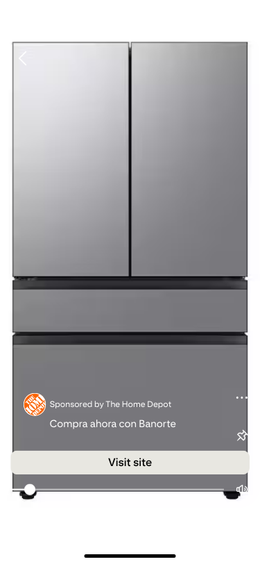 A sleek silver refrigerator with double doors on top and two drawers below. The Home Depot ad overlay reads "Compra ahora con Banorte."