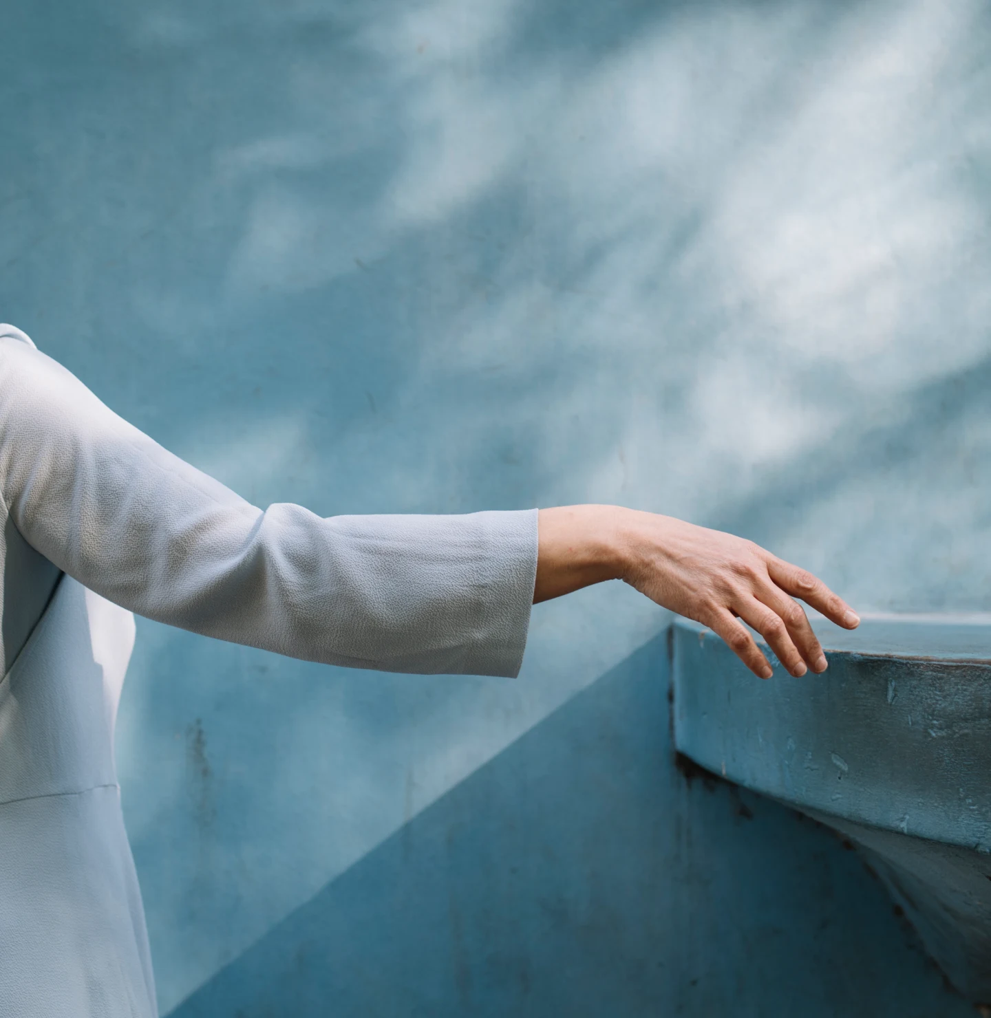 A woman's hand gestures at a wall