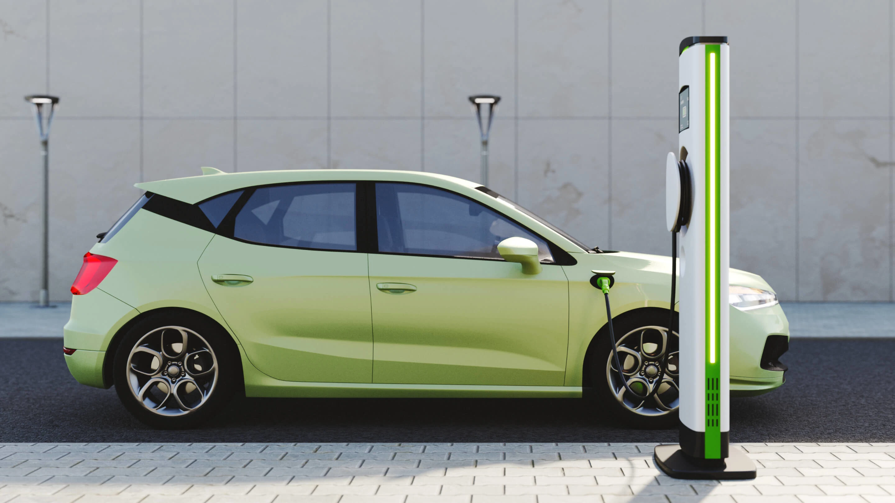 A green electric car is parked in front of a charging station, with a cable plugged into the car's charging port.