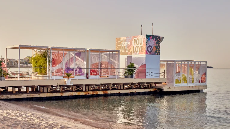 Il molo galleggiante "Crea la vita che ami" di Pinterest per Cannes 2022 sull'acqua calma.