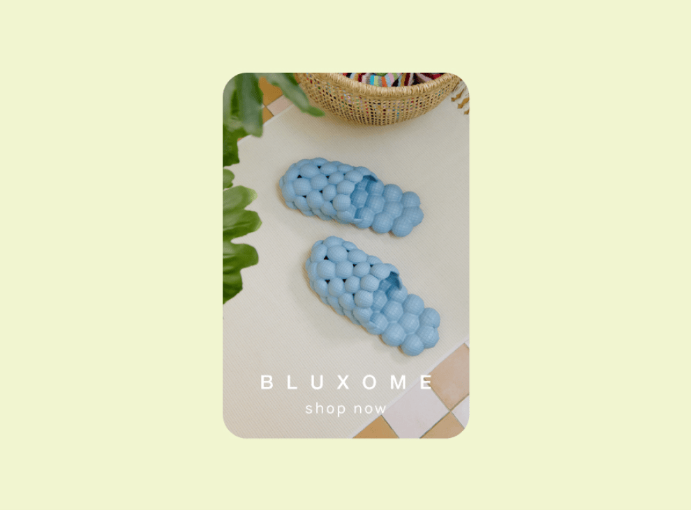 Advertisement featuring blue bubble slippers on a floor with a 'Shop Now' call-to-action text overlay.