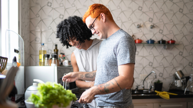 Two men are preparing a meal together in a kitchen.