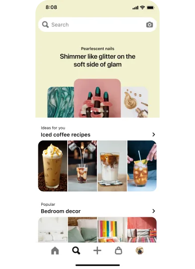 Вкладка поиска в мобильном приложении. В верхней части экрана расположена панель поиска с 3 пинами-идеями о дизайне ногтей, которые размещены один поверх другого под общим заголовком «Перламутровые ногти: мерцание и блеск для легкого налета гламура». Ниже расположен раздел с 4 пинами под заголовком «Идеи для вас: рецепты холодного кофе», а еще ниже — раздел с 4 пинами под заголовком «Популярны идеи: декор спальни».
