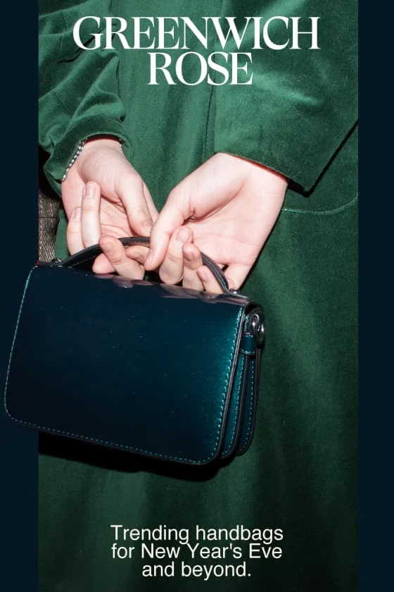 Pale hands holding a blue-green handbag against a green velvet coat