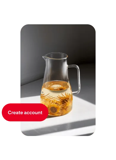 Pin of a glass pitcher filled halfway with water and orange flowers, with a ‘Create account’ button on the left.