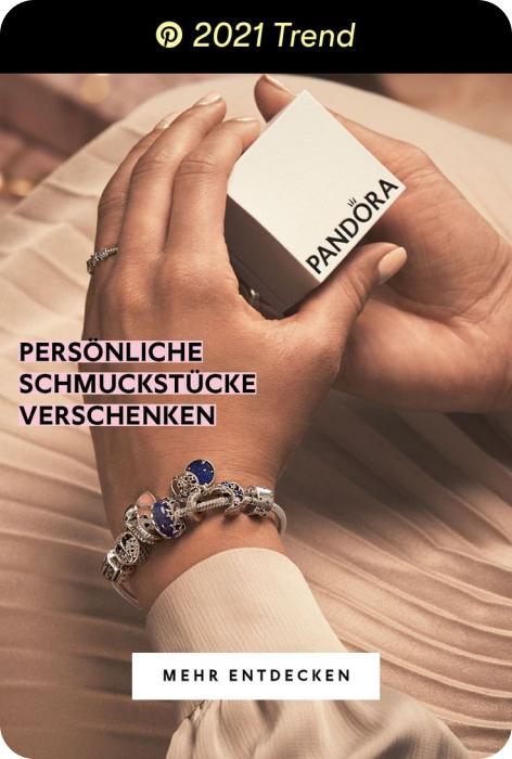 Person wearing pink skirt, white top, ring and bracelets holds white jewellery box