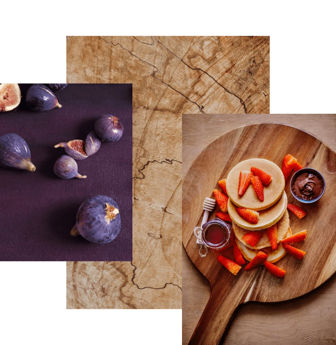 Image cluster featuring purple figs sliced open on a purple tablecloth, a close-up of a wooden cutting board and pancakes with strawberries, honey, and chocolate sauce displayed on a wooden charcuterie board