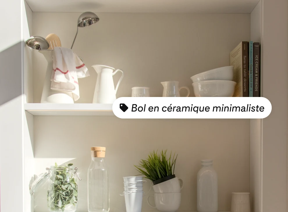 Deux étagères avec des vases et des bols blancs et trois livres à droite de l'étagère du haut, avec une étiquette de produit indiquant « bol minimaliste en céramique »