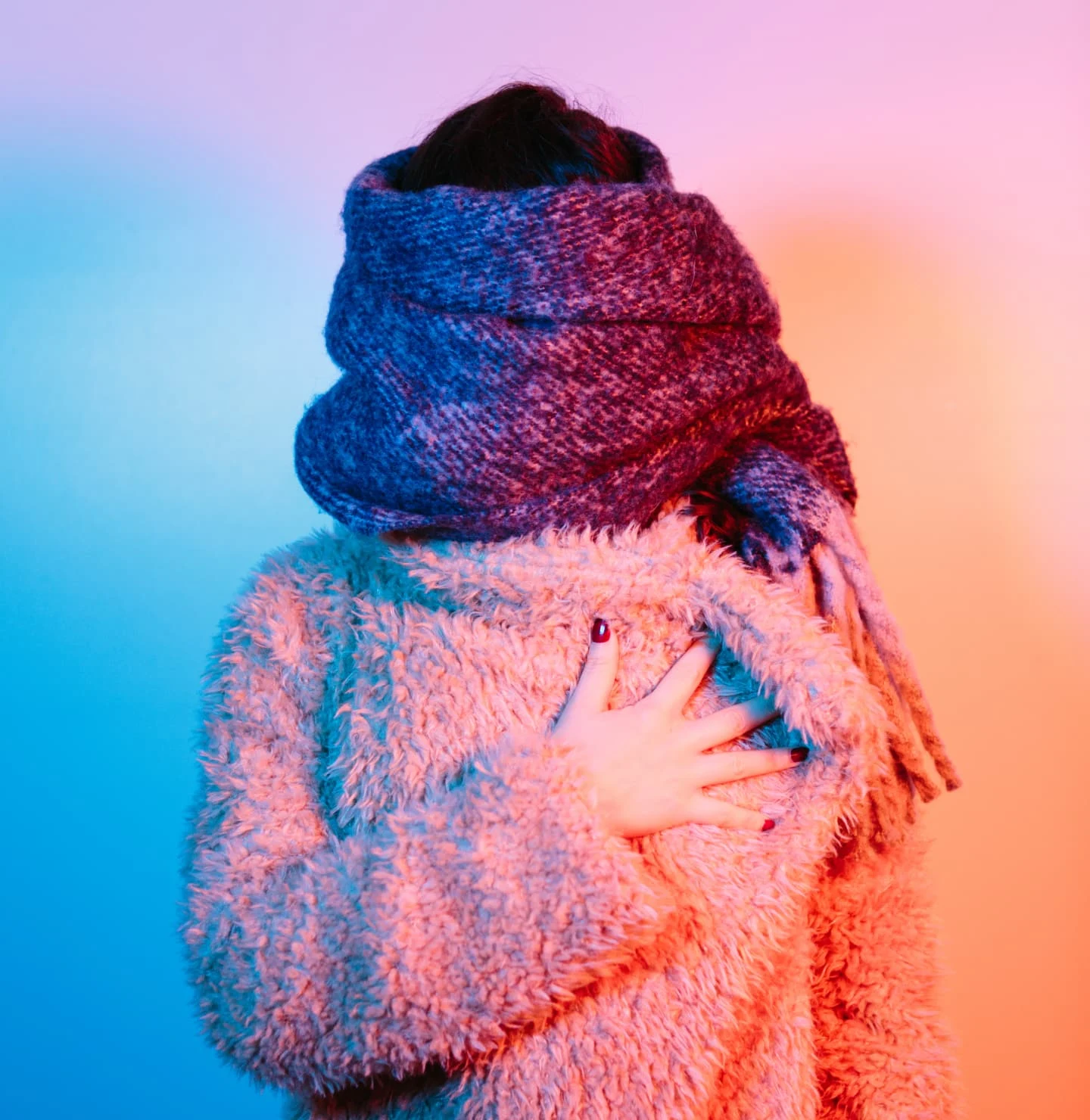 Woman wrapping herself in a scarf and sweater