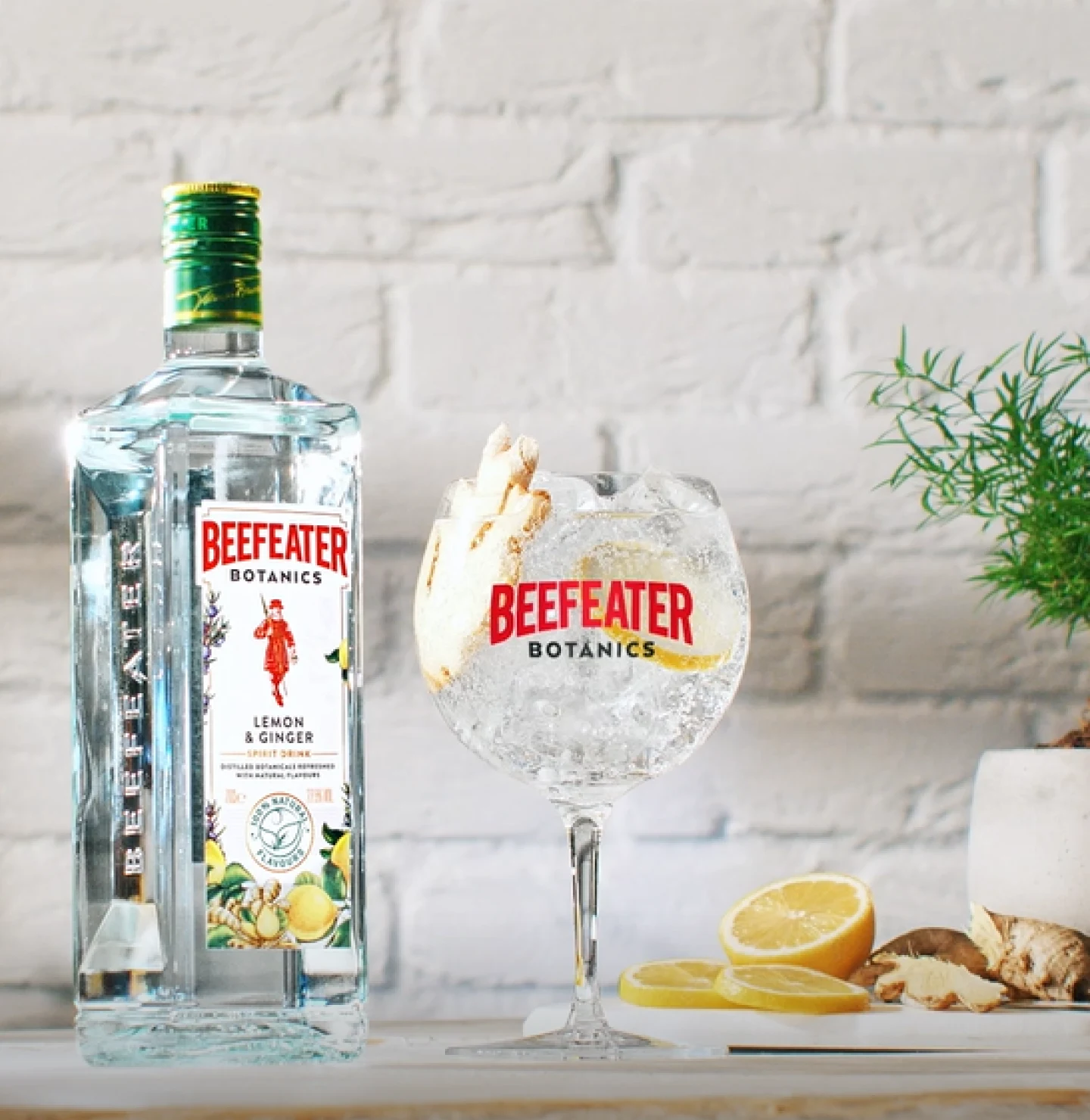 Beefeater gin bottle and a glass garnished with a lemon and ginger 