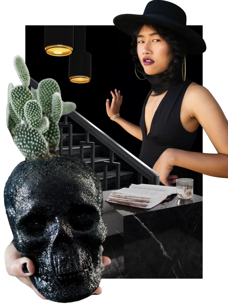 East Asian at right in a black hat, dress and scarf. Large black skull at lower left. Cactus plant at left. Dark staircase at center goes up to hanging black lamps. Black marble cube with a book and glass of water on top.

