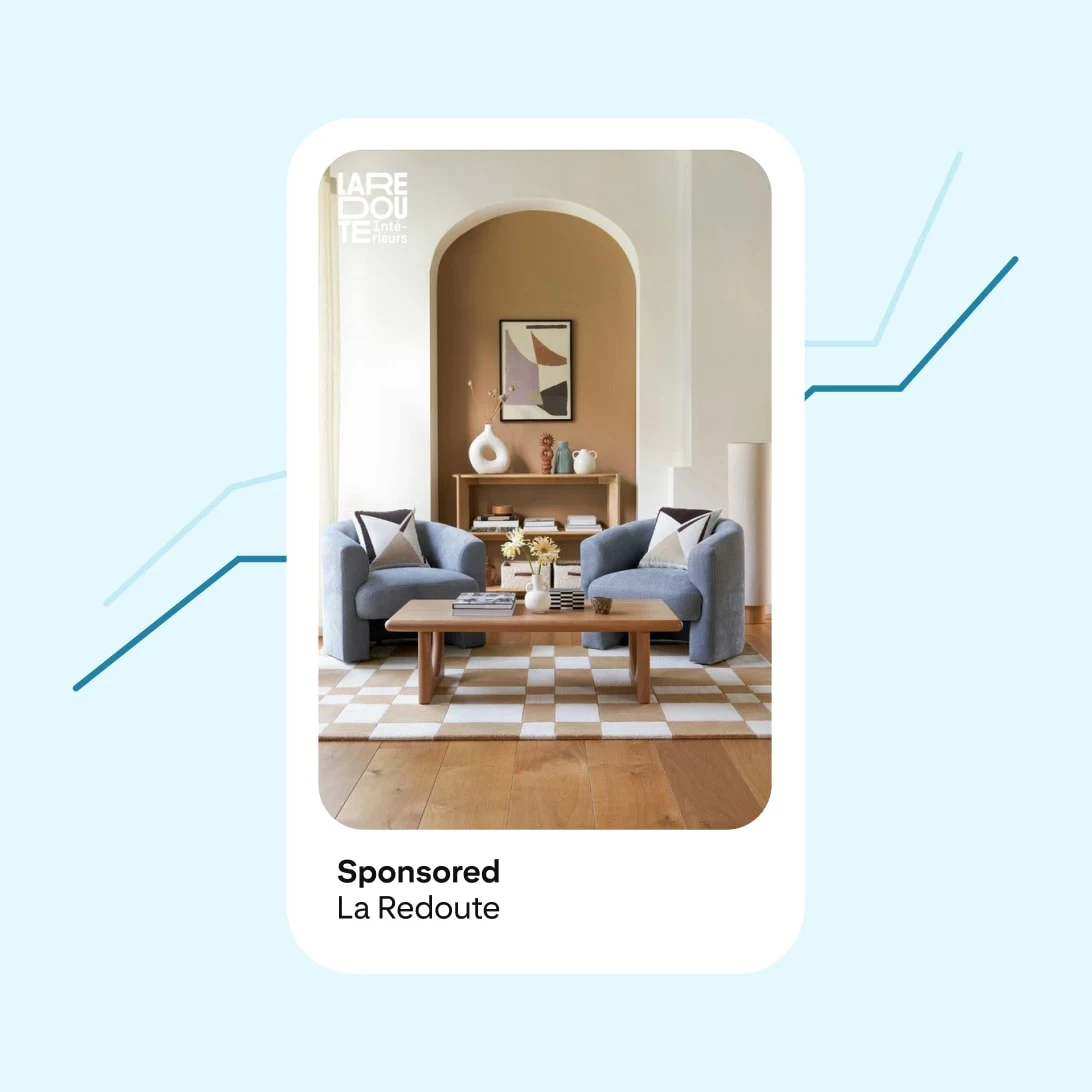 Smartphone ad showing a living room with gray armchairs, a wooden coffee table, checkerboard rug, and neutral decor. Sponsored by La Redoute.