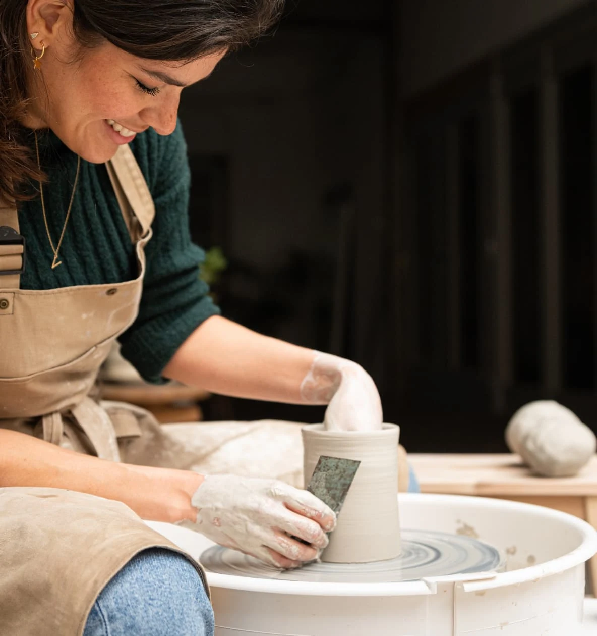 Person making a cup on pottery wheel
