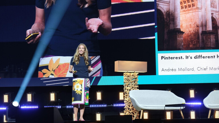 Andrea Mallard, CMO von Pinterest, wird auf einer Bühne gezeigt und hält eine große Präsentation bei OMR.