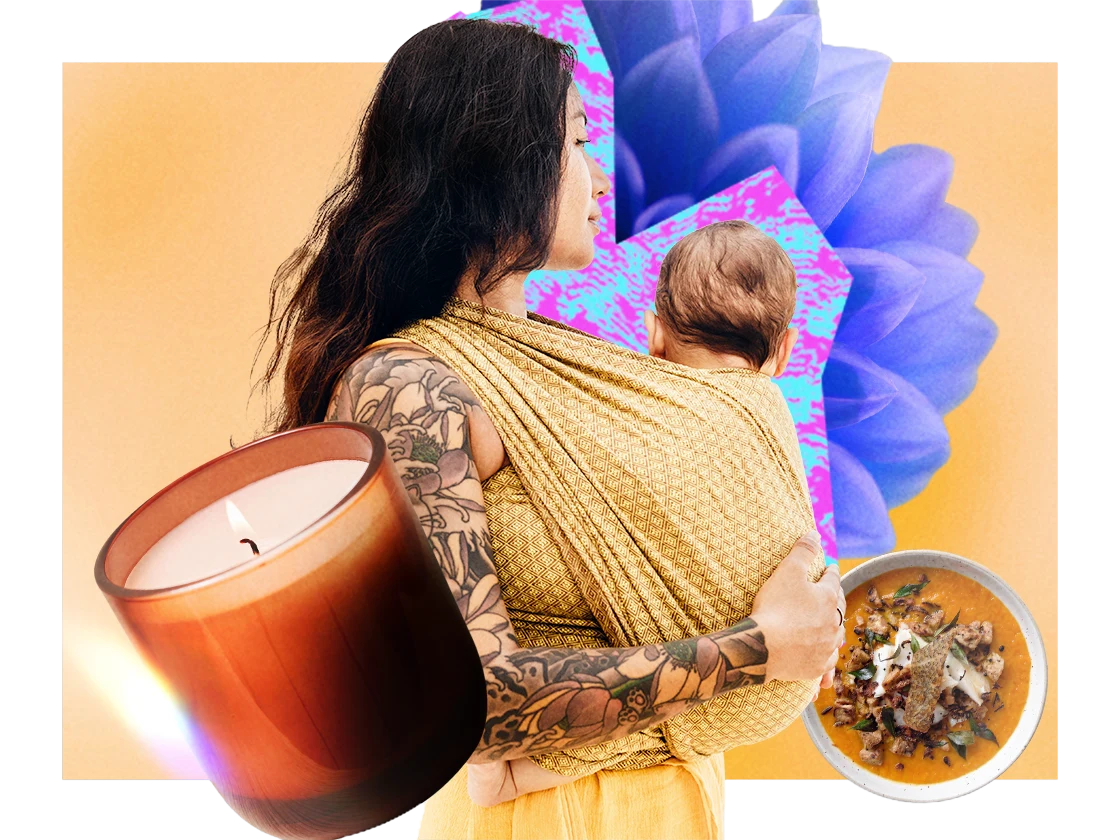 Una donna tatuata che trasporta un bebè in fascia circondata da vari oggetti tra cui una candela, petali di fiori e una zuppa. 