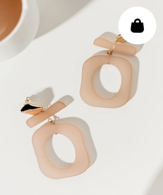 A set of pinkish-tan chunky earrings on a white background. 