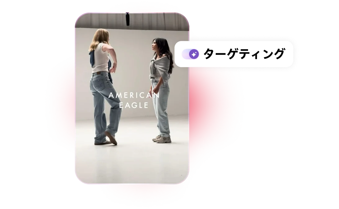 デニムを履き、セーターを肩にかけた 2 人の女性が会話をしながら立っている画像。