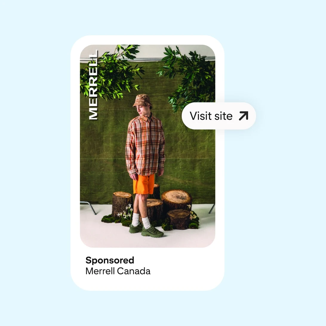 A man in an orange plaid shirt and beige shorts stands among wooden logs and greenery, wearing hiking boots. Text: "Visit site" and "Sponsored by Merrell Canada."