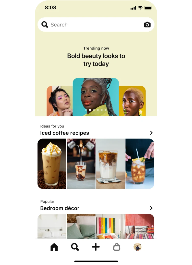 Image of a mobile app search tab with a top-aligned search bar showing three stacked nail Idea Pins titled ‘Pearlescent nails: Shimmer like glitter on the soft side of glam’. Below, a section titled ‘Ideas for you: Iced Coffee Recipes’ with four pins and another section titled ‘Popular: Bedroom décor’, also with four pins.