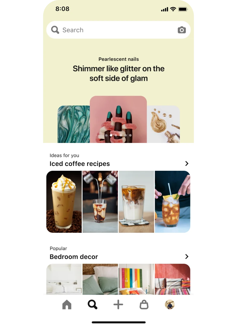 Вкладка поиска в мобильном приложении. В верхней части экрана расположена панель поиска с 3 пинами-идеями о дизайне ногтей, которые размещены один поверх другого под общим заголовком «Перламутровые ногти: мерцание и блеск для легкого налета гламура». Ниже расположен раздел с 4 пинами под заголовком «Идеи для вас: рецепты холодного кофе», а еще ниже — раздел с 4 пинами под заголовком «Популярны идеи: декор спальни».