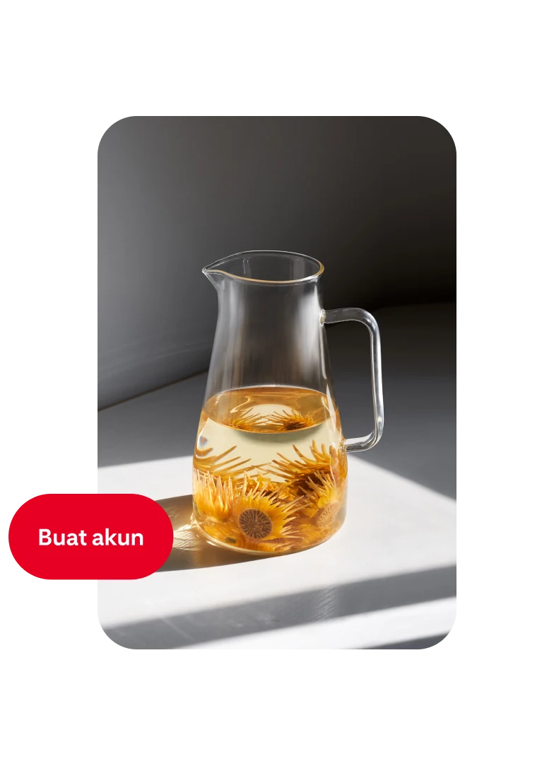 Pin teko kaca yang setengahnya diisi dengan air dan bunga oranye dengan tombol “Buat akun” di sebelah kiri.