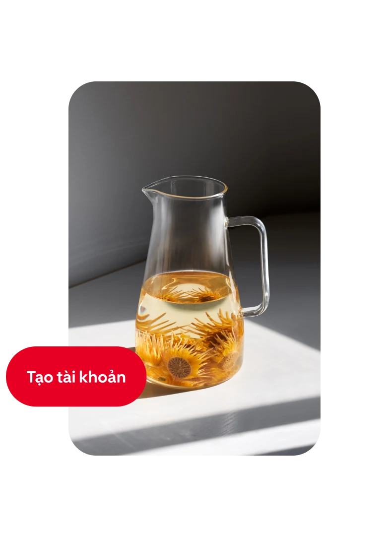 Ghim mô tả bình nước thủy tinh được rót đầy một nửa và những bông hoa màu cam với nút "Tạo tài khoản" ở bên trái.