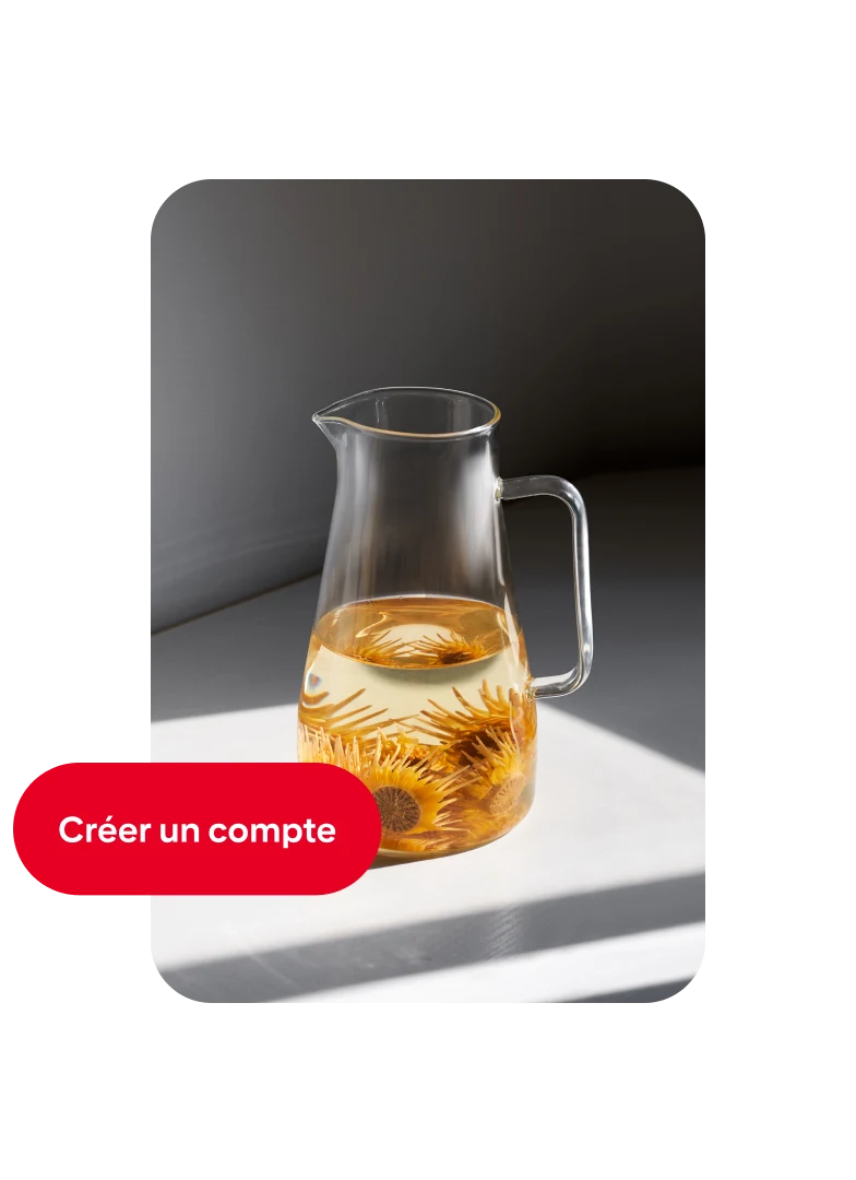 Épingle d’une carafe en verre remplie à moitié d’eau et de fleurs orange, avec un bouton « Créer un compte » sur la gauche.