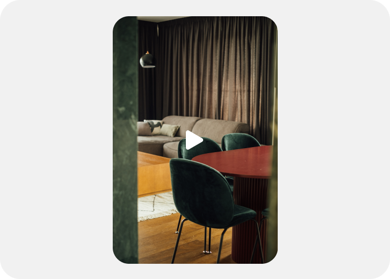 A Video ad highlights a lush room with a tan couch and a dining table with velvet chairs.