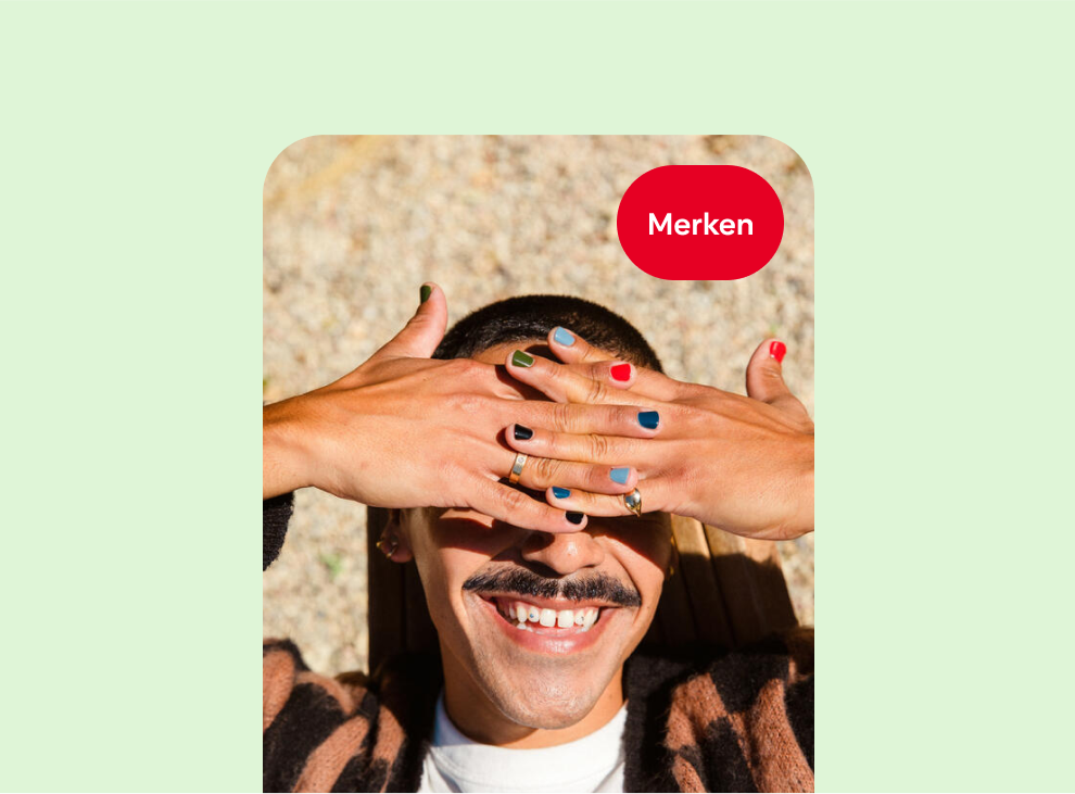 Eine lächelnde weiße Person hält sich die Hände vor die Augen; jeder Fingernagel hat eine andere Nagellackfarbe.