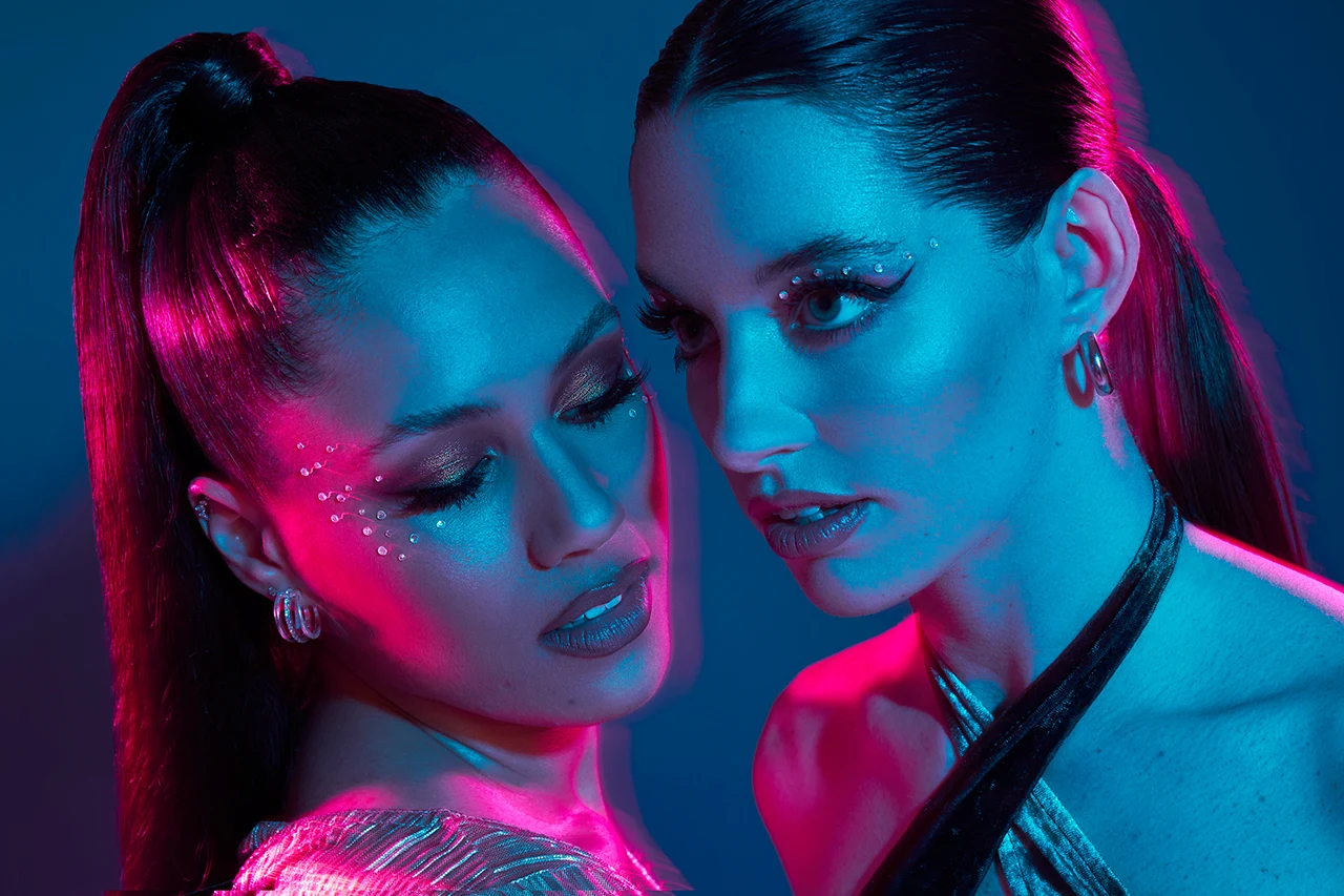 Close up of two women wearing dramatic make up styles