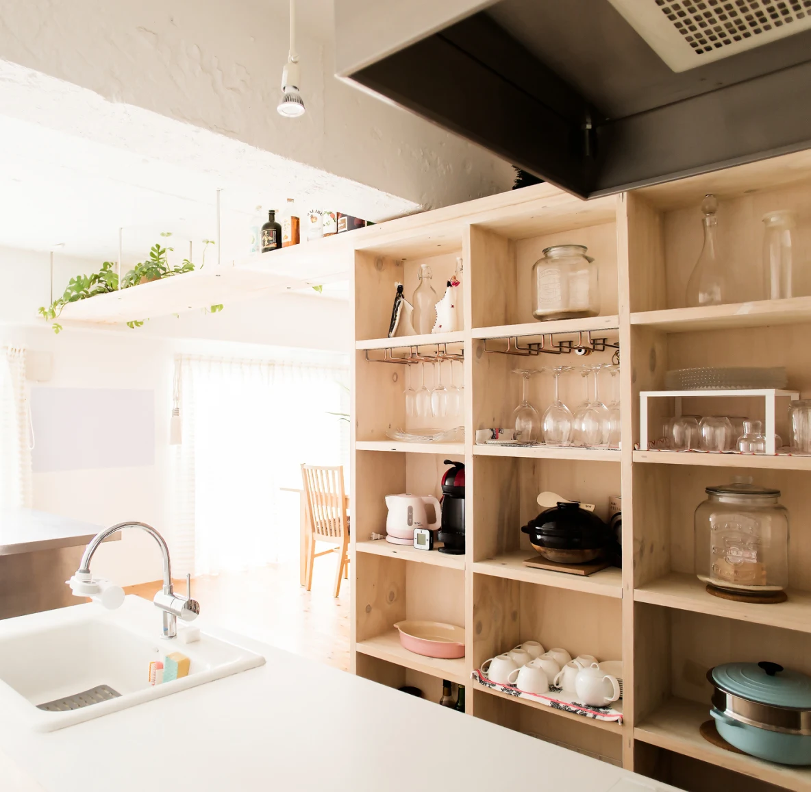 A wall of wood shelves in a brightly lit kitchen