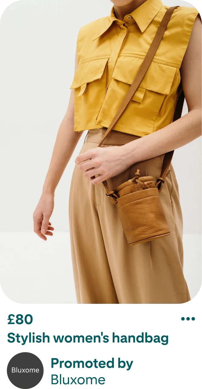 Image of a pin selling a women's handbag. The pin displays a person wearing a tan handbag. The handbag has a long strap and is drapped over their shoulder. The person in the image is wearing a collared, sleeveless yellow shirt with tapered khaki trousers. Below the image of the person, the cost and description of the handbag is listed. The listed price is $80 and the description reads: ‘Stylish women's handbag, promoted by Bluxome’. 