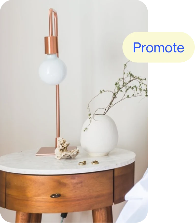 Circular wooden side table with white marble top, featuring a small white vase and simple bulb lamp