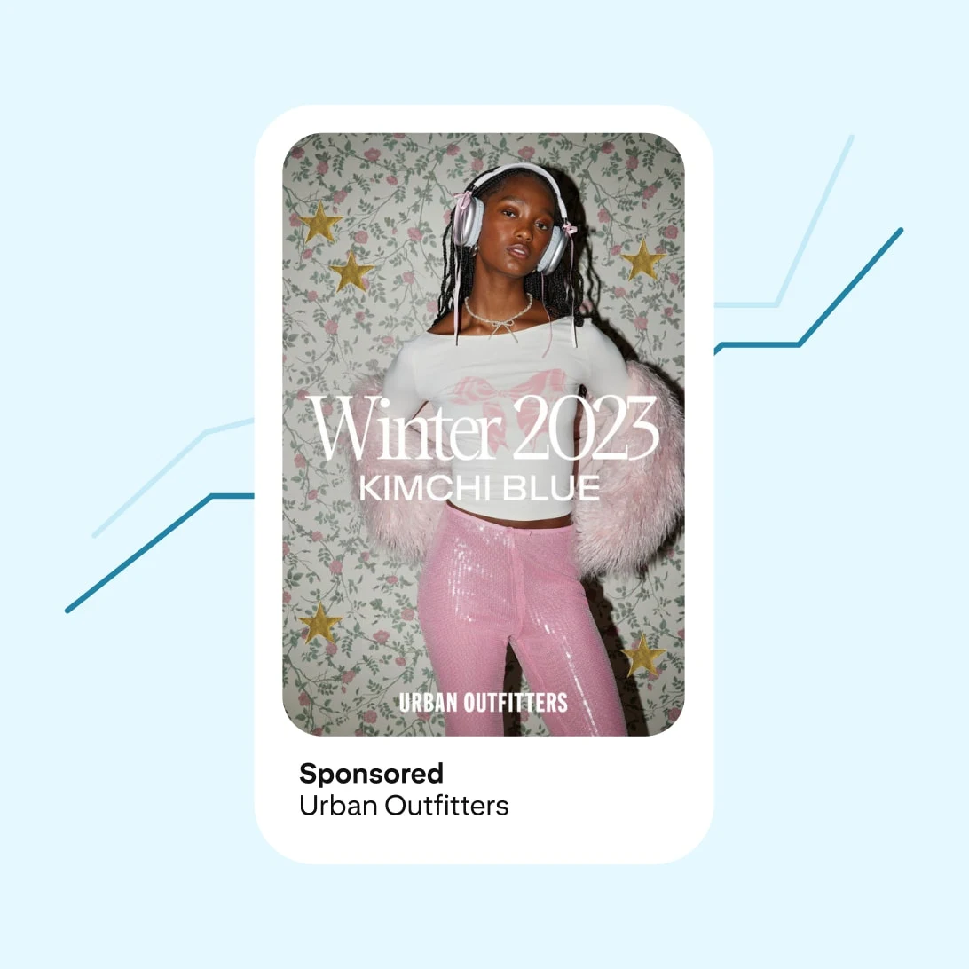 A woman wearing pink sequined pants and a white fur coat stands against a floral background. She has headphones on and looks directly at the camera. Text reads "Winter 2023 KIMCHI BLUE," sponsored by Urban Outfitters.