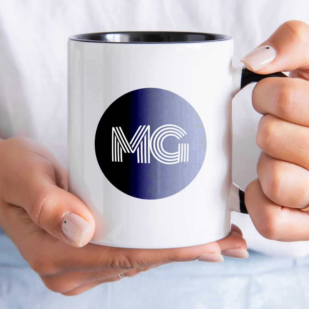 Monogram logo example of a white mug with black and purple gradient circle in center and "MG" initials in white Monoton font.