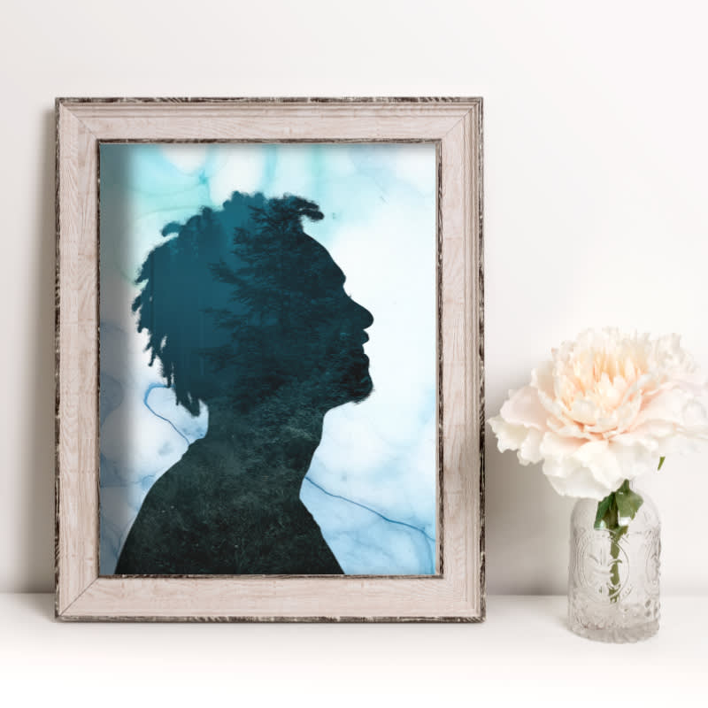 Double exposure silhouette photo placed inside a frame next to a flower vase