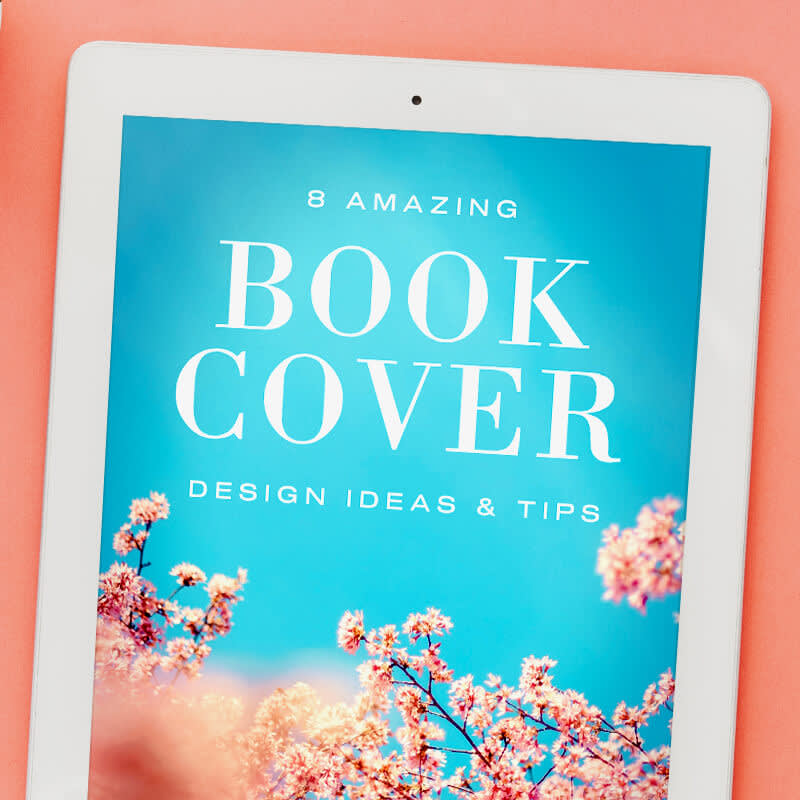 Vibrant light blue book cover on a white kindle device with bold white font that reads, "Amazing book cover design ideas & tips." The blue book color is supported by light pink flowers surrounding the bottom half. Background is salmon pink.