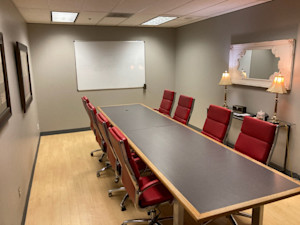 A conference room with red chairs at Legacy Office Center.