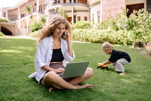 A young woman entrepreneur taking a business call from her front yard.