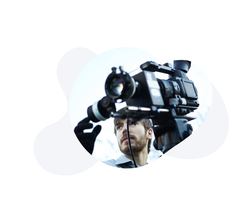 Image of a person holding a video camera and filming scenery. 