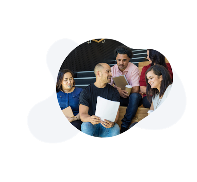 Image of a group of people looking at a sheet of paper and collaborating. 